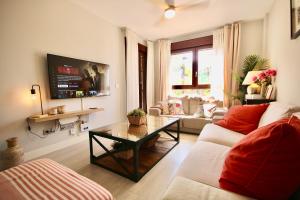 uma sala de estar com um sofá e uma mesa em Dos Mares Apartamentos Playa Granada em Motril