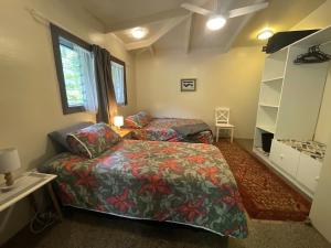 ein Schlafzimmer mit einem Bett, einem Bett und einem Fenster in der Unterkunft TE PUKA ESTATE Group & Function Venue in Rarotonga
