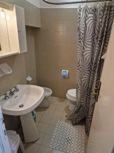 a bathroom with a sink and a toilet and a shower curtain at La Locanda di Bivigliano in Bivigliano