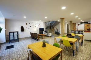 una habitación con mesas y sillas y una escalera en Hostel El Campano, en Villafranca del Bierzo