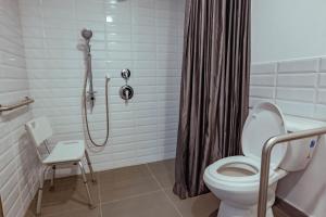 uma casa de banho com um chuveiro, um WC e uma cortina de chuveiro. em Spotty Bogotá Centro em Bogotá