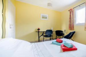 ein Schlafzimmer mit einem Bett mit roten und blauen Handtüchern darauf in der Unterkunft Maison Besun in Dieulefit