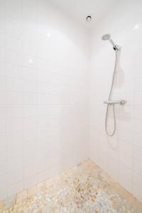 eine Dusche in einem weiß gefliesten Bad in der Unterkunft Maison Besun in Dieulefit