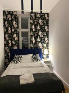 a bedroom with a large bed with floral wallpaper at Tabago Studio 16 in Nysa