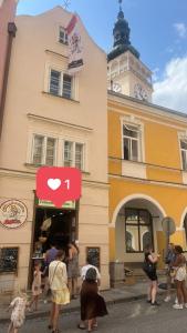 un grupo de personas de pie en frente de un edificio en ZMRZLINOVÝ DOMEČEK (Ice cream housei), en Mikulov