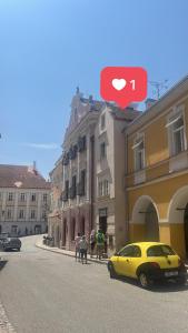 ein gelbes Auto, das vor einem Gebäude parkt in der Unterkunft ZMRZLINOVÝ DOMEČEK (Ice cream housei) in Mikulov