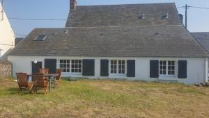 a house with a table and chairs in front of it at la maisonnette à 1200 m de la mer in Agon Coutainville