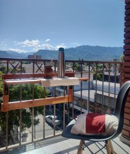 una mesa y una silla en un balcón con montañas en Dpto Microcentro, vista panoramica en La Rioja