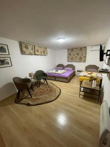 a room with two beds and a table and chairs at Ori in Podgorica