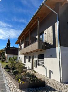 un edificio blanco con balcón y iglesia en Chiemgauloft am Chiemsee en Übersee