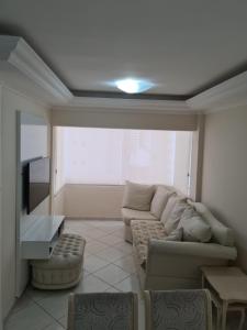 uma sala de estar com um sofá e uma televisão de ecrã plano em Apartamento Beira-Mar em Balneário Camboriú