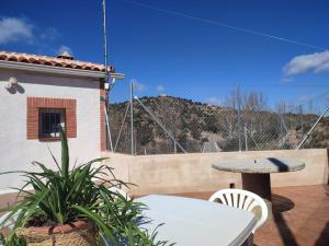 einen Tisch und Stühle auf einer Terrasse mit Bergblick in der Unterkunft Alojamiento Turístico La Cantuérgana in San Martín de Montalbán