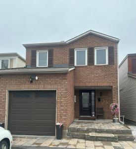 a brick house with a brown garage at Cute 2 beds room , for females only in Ottawa