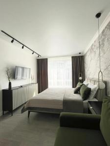 a white bedroom with a bed and a couch at Warm cozy apartment with fast wi-fi in Tbilisi City