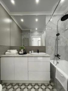 a white bathroom with a tub and a sink at Warm cozy apartment with fast wi-fi in Tbilisi City