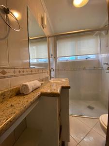 uma casa de banho com um lavatório e um chuveiro em Apartamento Beira-Mar em Balneário Camboriú