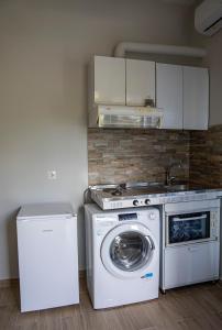 a kitchen with a washing machine and a washer at Nikitas Apartments & Suites in Kanali