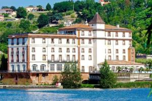 a large building next to a body of water at La villa des Mûriers très spacieuse de 1 à 8 voyageurs avec lit bb dans un environnement calme dans les coteaux in Malause