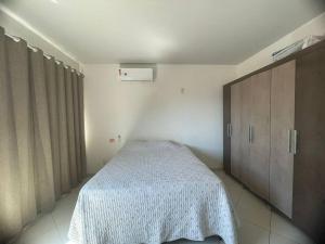 ein Schlafzimmer mit einem Bett mit einer weißen Decke darauf in der Unterkunft aluguel show safra disponível nos dias 19, 20, 21 e 22 in Lucas do Rio Verde