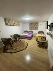 a living room with two beds and a table at Ori in Podgorica