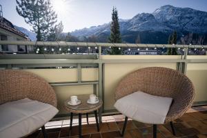 two chairs and a table on a balcony with mountains at Pott-Alm in Bad Reichenhall