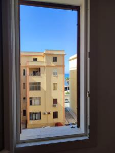 a window with a view of a building at TRAPANI CITY SEA APARTMENT in Trapani