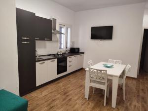 a kitchen with a white table and a black refrigerator at TRAPANI CITY SEA APARTMENT in Trapani