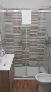 a bathroom with a shower and a toilet and a sink at TRAPANI CITY SEA APARTMENT in Trapani +14 photos