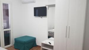 a bedroom with a white cabinet and a blue stool at TRAPANI CITY SEA APARTMENT in Trapani