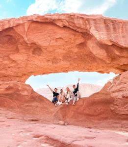 a group of people sitting on a rock formation at Tamim Luxury Camp in Wadi Rum
