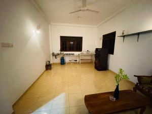 an empty living room with a kitchen and a table at Shiv's Villa in Galle