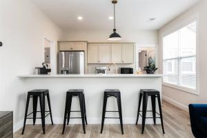 a kitchen with three bar stools at a counter at Victory Views Estate: Luxury Guest Loft in South Bend