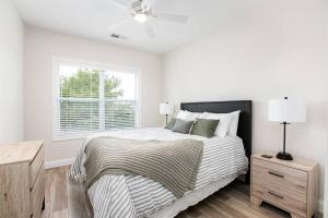 a white bedroom with a bed and a window at Victory Views Estate: Luxury Guest Loft in South Bend