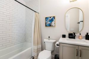 uma casa de banho com um WC, um lavatório e um espelho. em Victory Views Estate: Luxury Guest Loft em South Bend