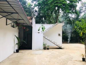 a house with a staircase in the courtyard at Shiv's Villa in Galle