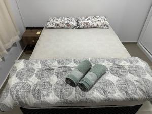 a bed with two pillows on top of it at Apartamento em vila Industrial Bloco 03 Ap 202 in Toledo