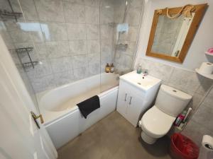a bathroom with a toilet and a tub and a sink at Peaceful 3 Bedroom House wFree Parking Nature in Falmer