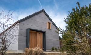 uma pequena casa cinzenta com uma porta castanha em Chalet Herz³ em Hohenau