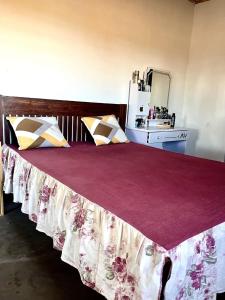 a bedroom with a large bed with a red blanket at TENDRY in Toliara