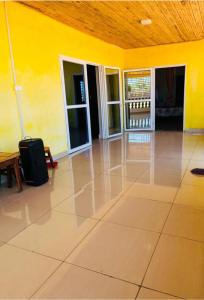 an empty room with a yellow wall and a suitcase at TENDRY in Toliara