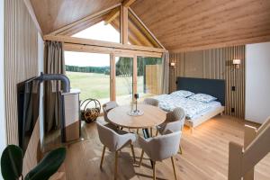 a room with a bed and a table and chairs at Chalet Herz³ in Hohenau