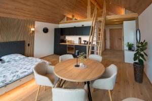 a small apartment with a bed and a table and chairs at Chalet Herz³ in Hohenau