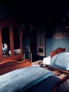 a bedroom with two beds and a chair at L'ancien Mystic ManOir DeDame in Ventron