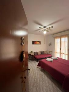 a bedroom with a red bed and a couch at B&B Il Girasole in Ortonovo