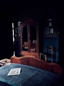 a bedroom with a bed with a table and a mirror at L'ancien Mystic ManOir DeDame in Ventron