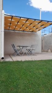 a picnic table and chairs under awning on a patio at Casa Los Teritos, Ruta del Vino in Maipú