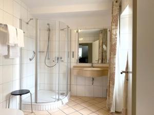 uma casa de banho com um chuveiro e um lavatório. em Zum Simonbräu em Bitburg