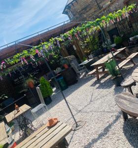 a patio with benches and tables with plants and flowers at Hope and Anchor in Wirksworth