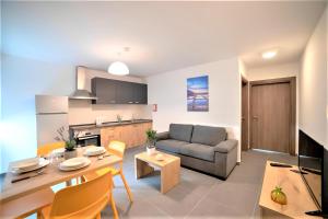 a kitchen and living room with a couch and a table at Elise Apartments in Il-Gżira