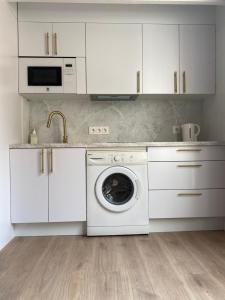 cocina blanca con lavadora y fregadero en Apartamento Plaza de las Flores, en Murcia
